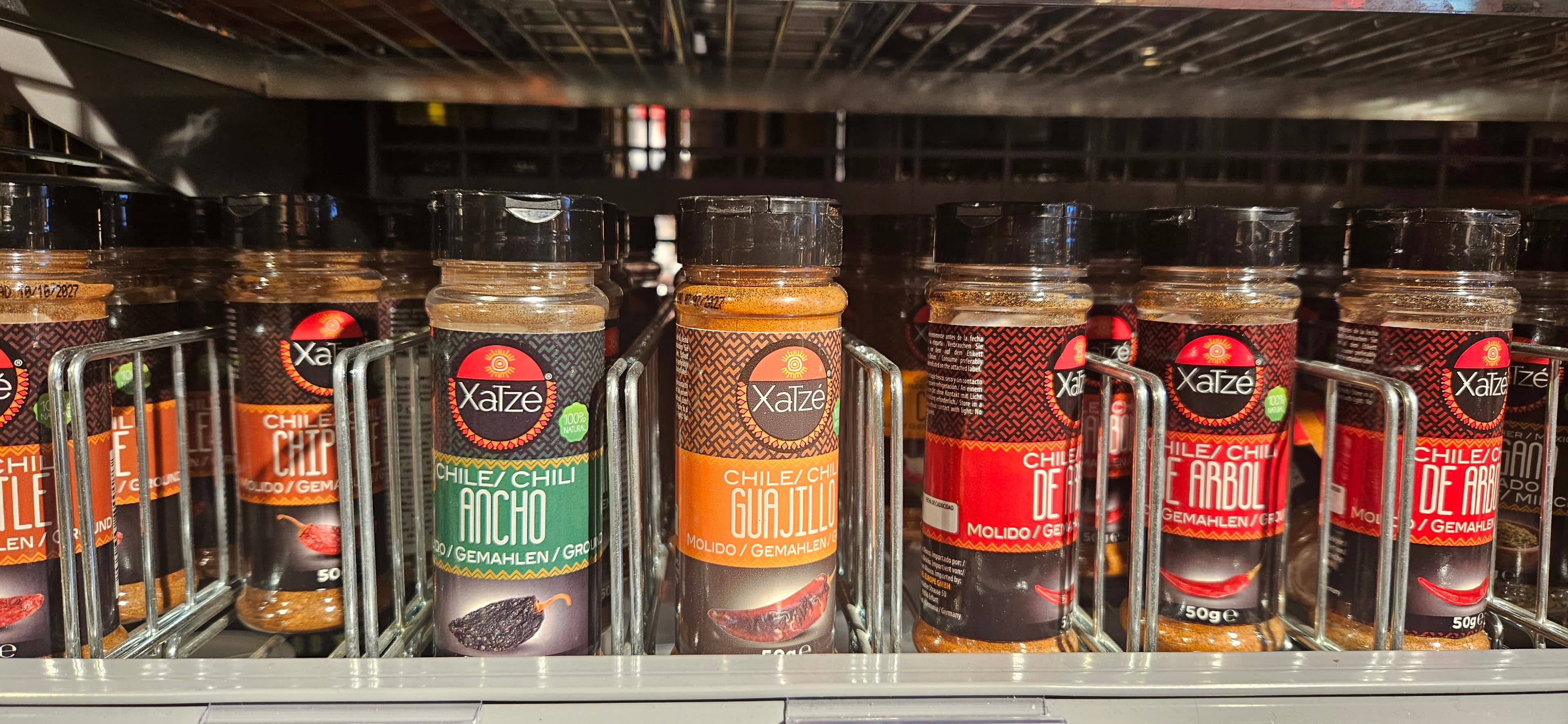 dried chilis on a store shelf, taken from the user's phone